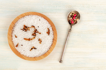 Gourmet spices. A bowl of sea salt infused with truffle shavings, and a peppercorn mix, shot from the top on a dark rustic white wooden background with copy space