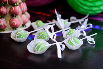 Green cakepops on candy bar