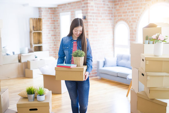 Beautiful asian young woman holding boxes, smiling happy moving to a new home