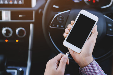 close up businessman in hand holding charge the battery phone in car. While traveling