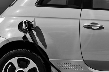 small electric car on charge in black and white
