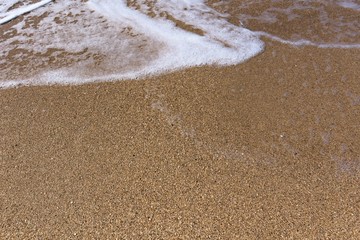 sea foam on the sand of Golden color. close up