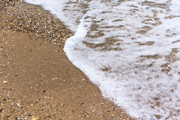 sea wave foam sand gold color. close-up , white foam