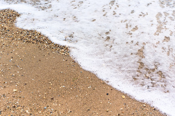 sea wave foam sand gold color. close-up , white foam