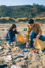 Young volunteers picking up trash on the beach