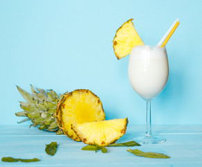 Milkshake of pineapple over a wood blue background