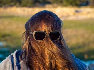 A curvy woman making funny gestures with hair in front of his face and sunglasses