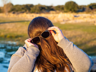 A curvy woman making funny gestures with hair in front of his face and sunglasses