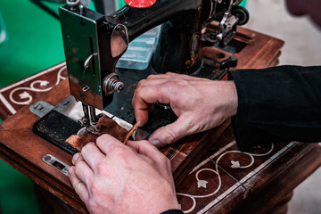 Close up shot of an old vintage sewing machine. Traditional handcraft, 19th century industrial technology. Macro photography, manufactoring concept. 