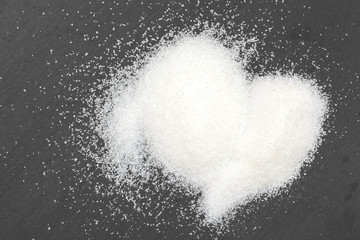 Obraz na płótnie Canvas Heart shape drawn on granulated sugar as a background