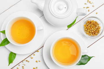 teapot and cups of tea on a white wooden background