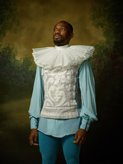 Young man as a medieval grandee or nobleman on dark studio background. Looking serious. Portrait of...