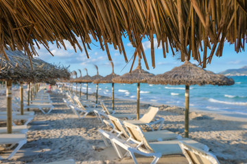 Fototapeta na wymiar Empty deck chairs and umbrellas on the beach of Muro, during Summer Time, Majorca, Mallorca Island, Spain