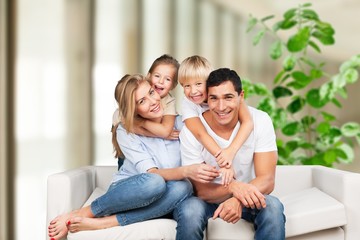 Obraz premium Beautiful smiling family sitting at sofa at home