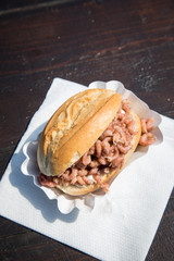 Nordseekrabben Brötchen als Fischbrötchen auf Fischmarkt Holztisch als schneller regionaler Imbiss