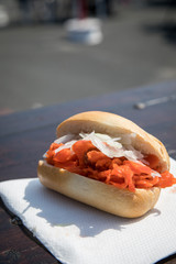 Alaska-Seelachs Brötchen mit Zwiebeln als Fischbrötchen auf Fischmarkt Holztisch als schneller regionaler Imbiss