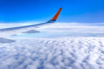 Obraz premium Bussiness and travel concept. Aerial view through window inside aircraft cabin with beautiful blue sky and cloud with sunlight, copy space, top view