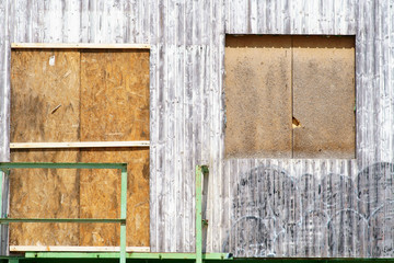Die Seitenansicht eines alten Bauanhängers aus Holz, welcher mit Spanplatten zugenagelt wurde. .