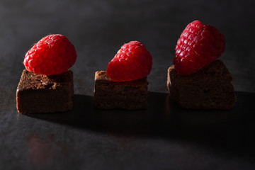 Chocolate brownies with raspberry topping. Low key lighting