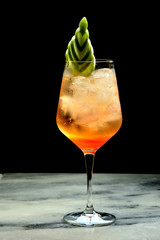 cocktail in frosted glass with cucumber garnish