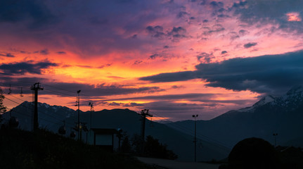 Panoramic view of color sunset in mountains. Travel background with sky and clouds