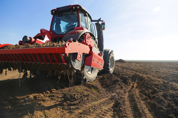 A farmer on a tractor prepares the land in the spring to start planting.