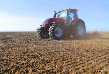 Farmer on tractor prepares land in spring