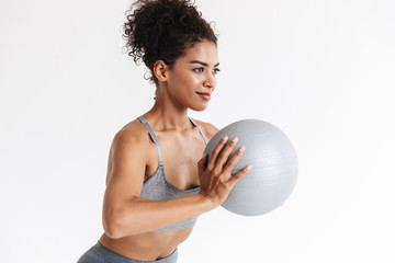 Naklejka premium Young amazing sports fitness african woman posing isolated over white background make exercises with ball.