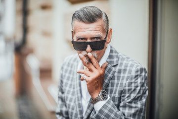 Serious  senior businessman in a fashionable stylish with the cuban cigarette