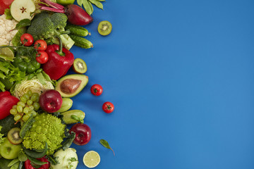 Healthy food dish on blue background. Healthful set including vegetables and fruits. Grape, apple,...