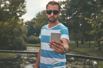Fototapeta premium Trendy man using cellphone outdoors.