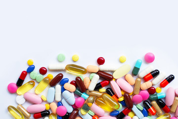 Colorful tablets with capsules and pills on white.