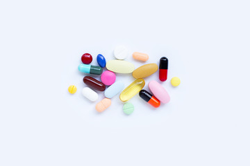 Colorful tablets with capsules and pills on white.