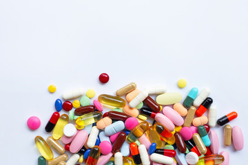 Colorful tablets with capsules and pills on white.