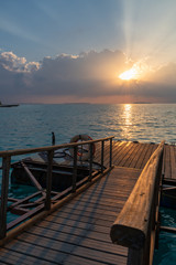 Obraz premium mała przystań w oceanie z paskami cienia podczas zachodu słońca