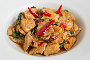 Stir-fried hot and spicy pork with holy basil on white