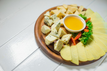 Cheese platter with different cheese, honey and vegetables