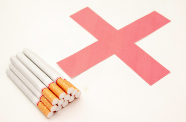 World No Tobacco Day; Heap of cigarettes with filter isolated on white background and Red cross symbol.