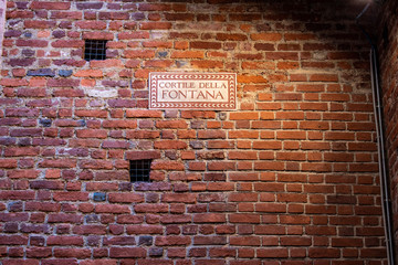 Fototapeta na wymiar Milan, Sforza Castle: the sign of Cortile della Fontana, the fountain court, little courtyard in the Museum of ancient art housing works ranging from the early Christian age to XVI century