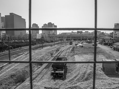  Seoul, South Korea - March 2018: photo taken from behind a grating, view of the station with rails and gravel. city ​​background. Black and white.