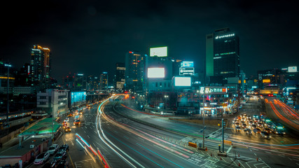 Seoul, South Korea - March 2018: long exposure of an urban landscape that incorporates moving cars and illuminated buildings, from a raised point during the night.