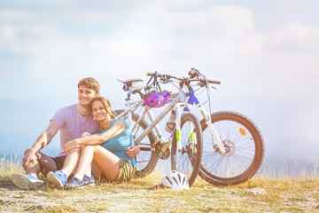 Fitness, sport, people and healthy lifestyle concept - happy couple riding bicycles outdoors at summer