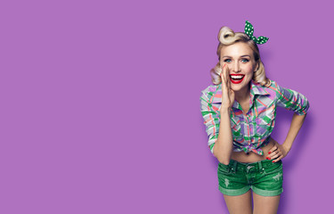 Photo of young happy smiling blond girl in pinup style, against violet background