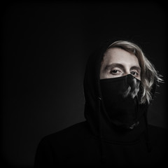 Young Masked Man over Black Background with Smoke