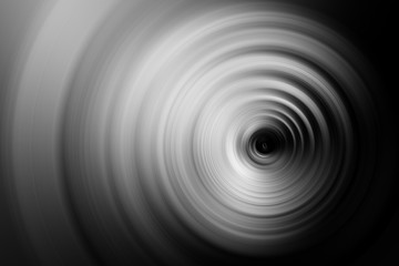 Abstract black and white background. Concentric monochrome circles with a black hole in the cente