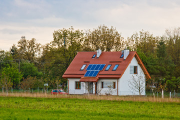 Fototapeta na wymiar solar battery on the roof of a rural house under a blue sunny sky. solar energy, alternative electricity
