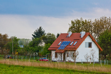 solar battery on the roof of a rural house under a blue sunny sky. solar energy, alternative electricity