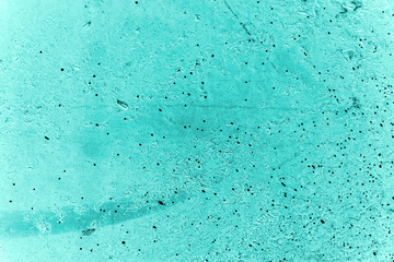 Vintage azure background. Rough painted wall of turquoise color. Imperfect plane of cyan colored. Uneven old decorative toned backdrop of aqzure tint. Texture of teal hue. Ornamental stony surface.