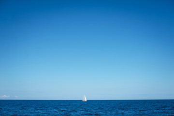 Fototapeta premium Alone boat at an open sea in the sunny weather day, Greece. Free space for text or logo