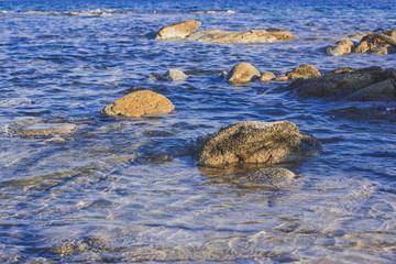 picturesque rocky stone waterfront of lake with shallow water, nature scenery landscape background photography 